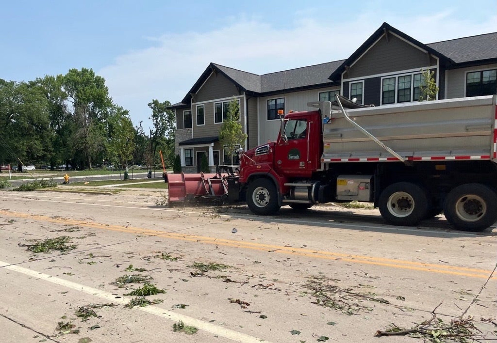 A snow plow clearing storm debris from streets on Doty Island in Neenah, Wisconsin