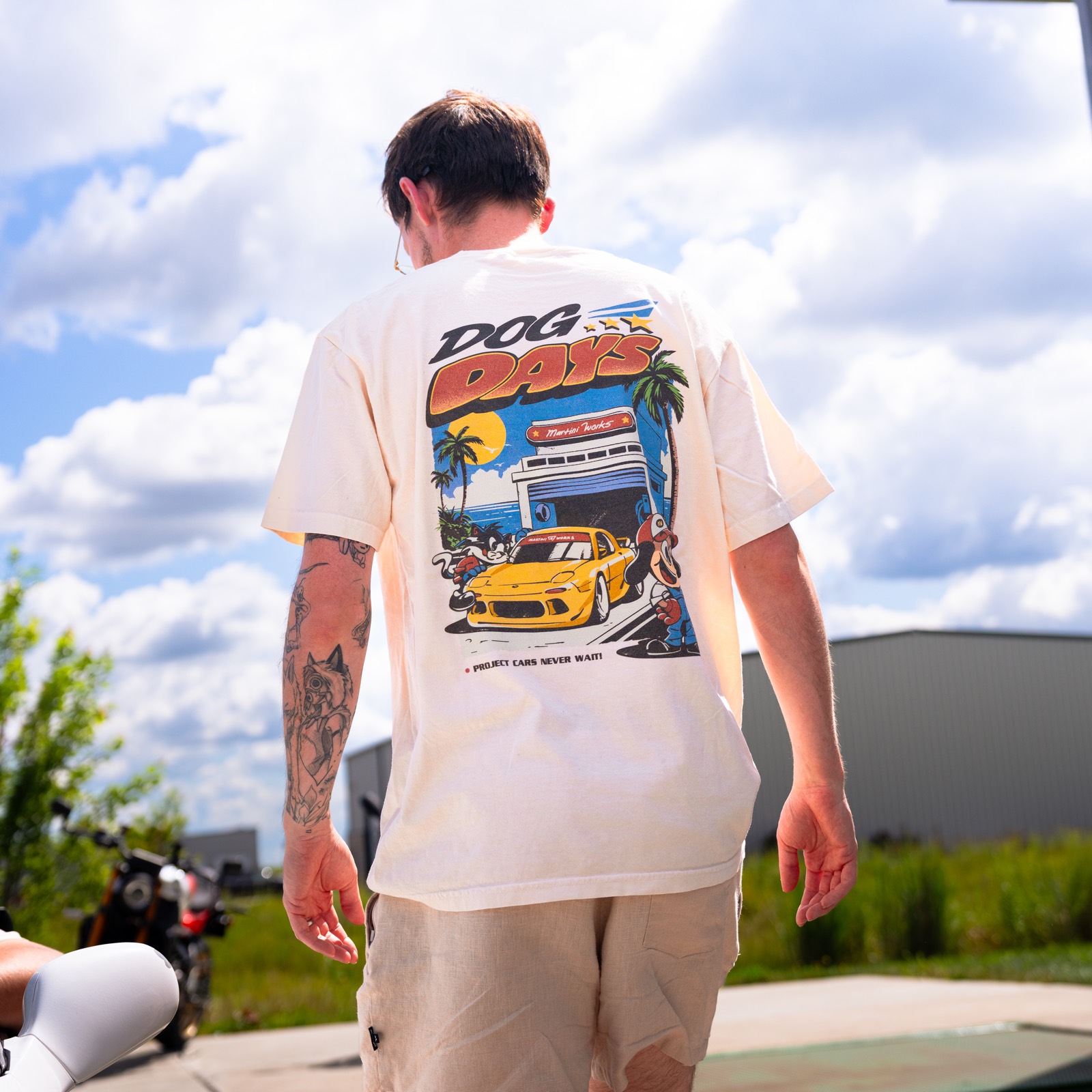 The back of a natural Dog Days tee worn outside the MartiniWorks shop